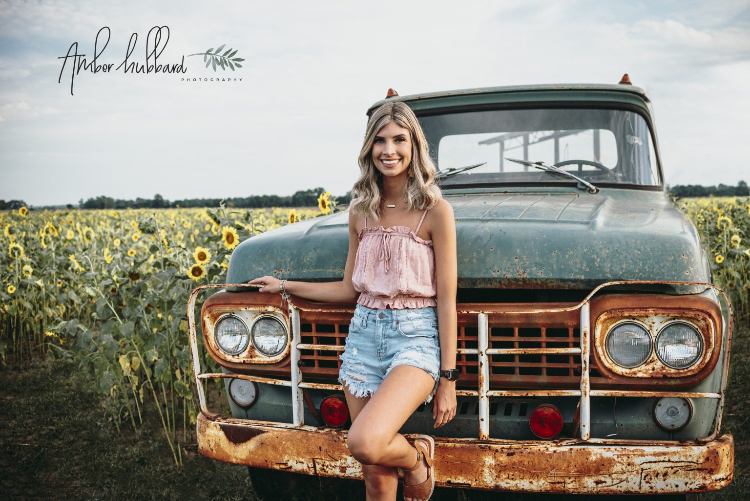 Senior with a vintage truck in the sunflower field