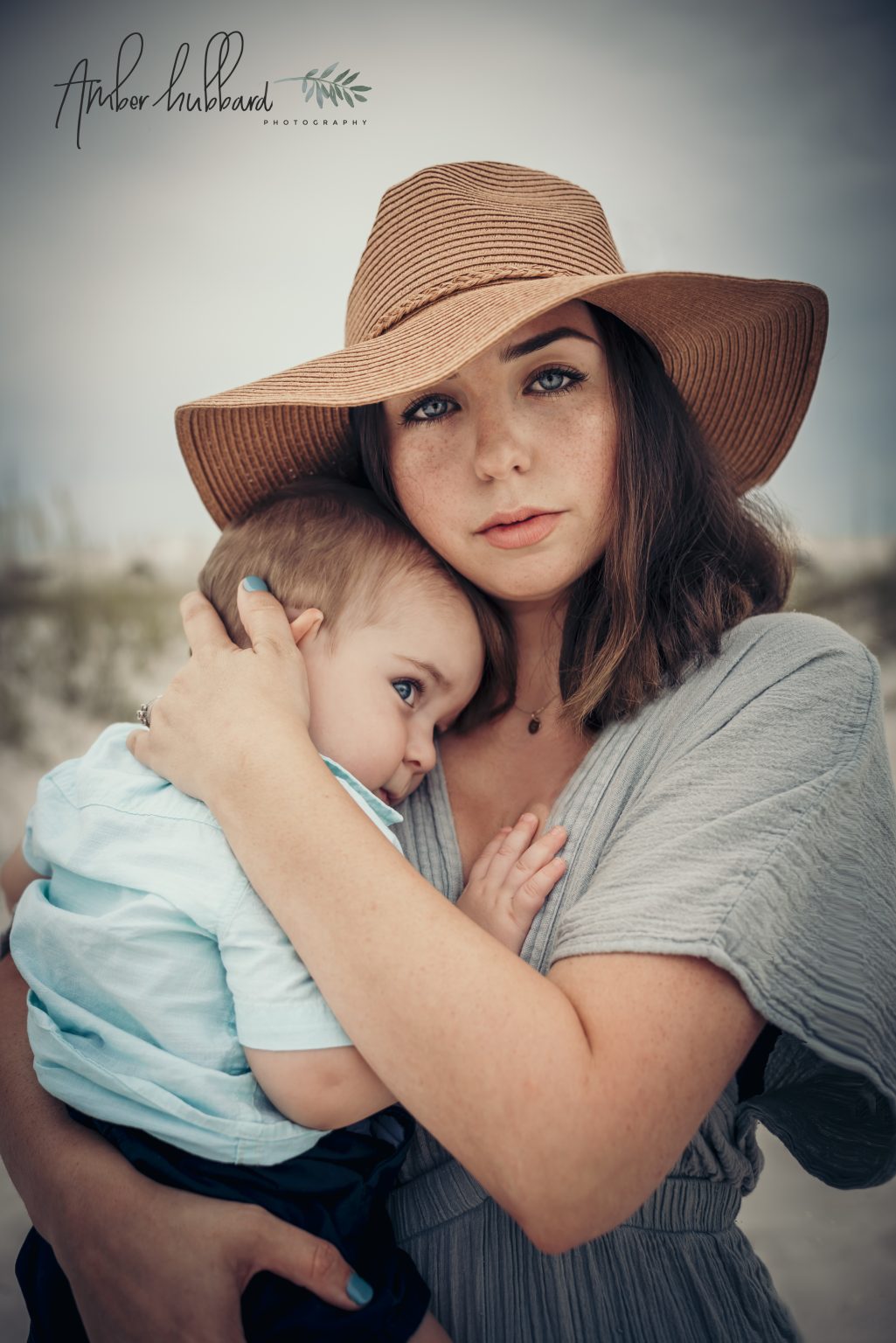 Mother in a sun hat snuggling her baby