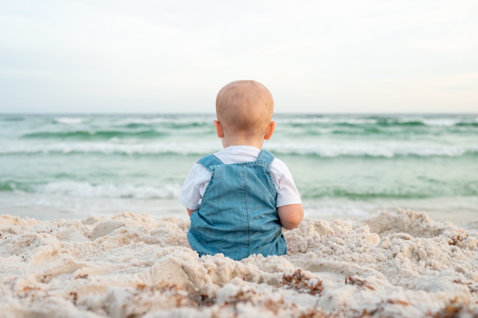 Baby sitting in the sugar-white sand watching the Gulf