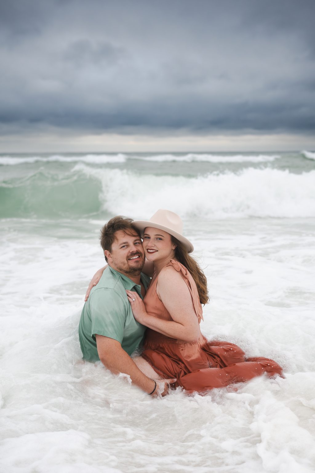 Couple sitting together in the rolling waves