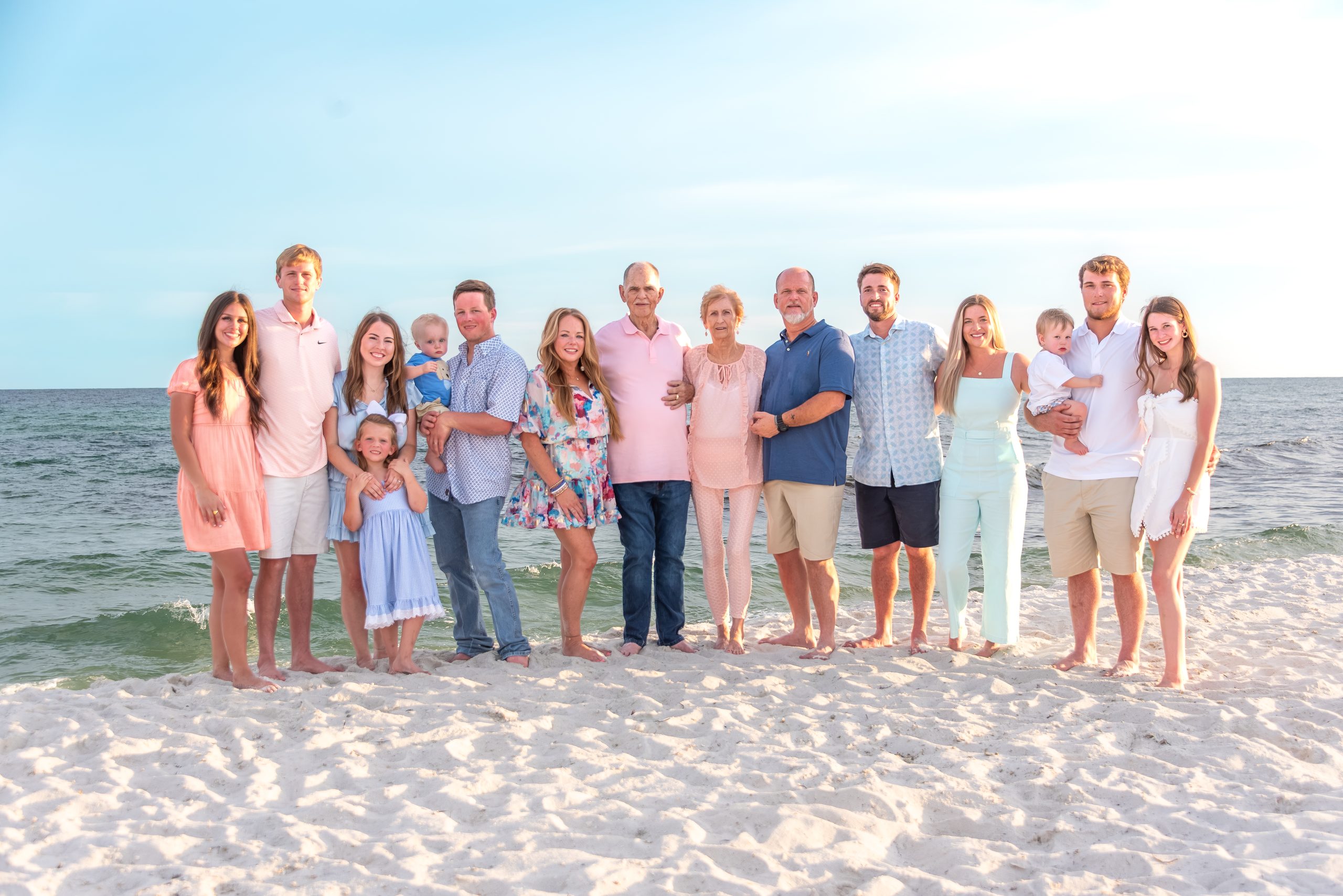 Navarre Beach extended family photographer — three generations together on the sand at golden hour