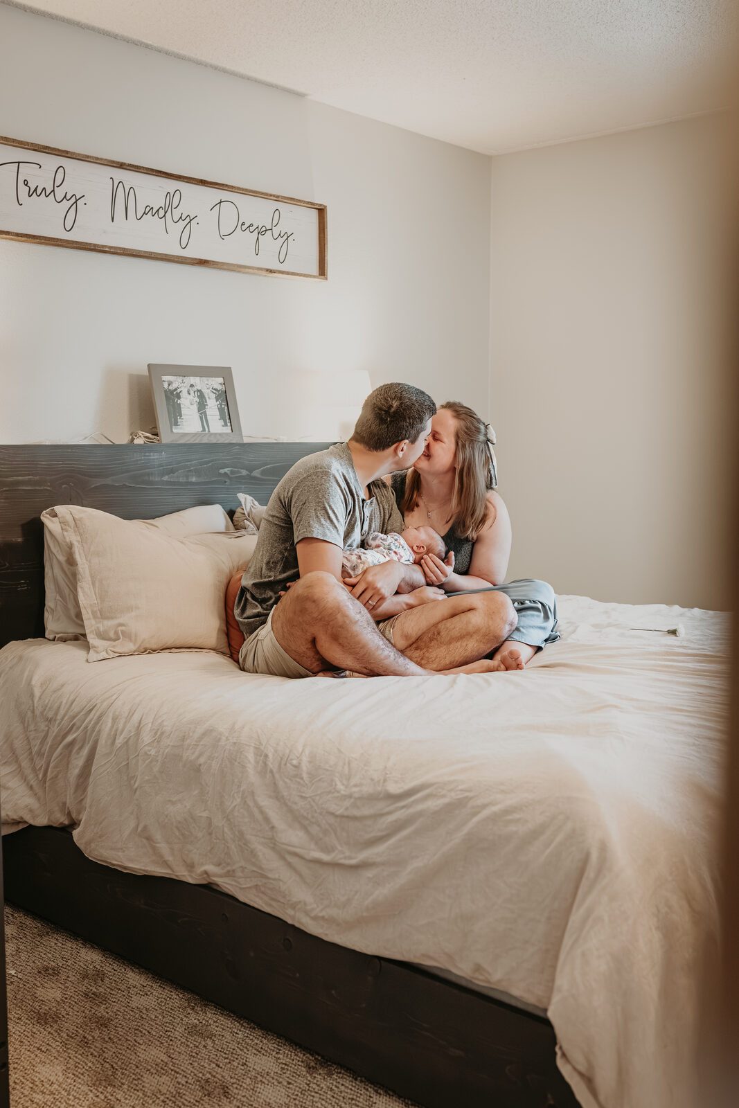 Parents holding their newborn at home during a lifestyle session near Navarre Beach